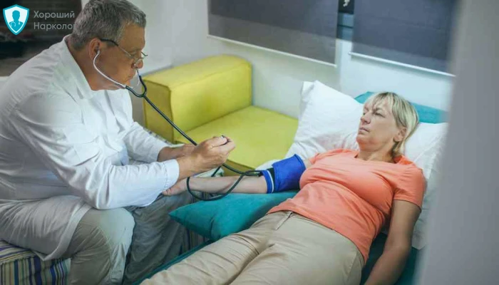 Врач мерит давление пациентке перед детоксикацией от наркотиков на дому
